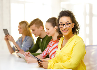 Image showing smiling female students with tablet pc at school