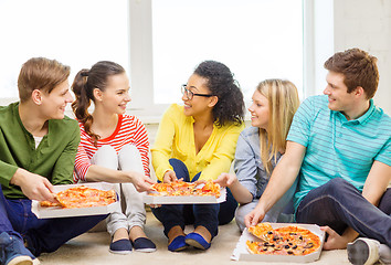 Image showing five smiling teenagers eating pizza at home