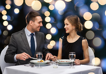 Image showing smiling couple eating main course at restaurant