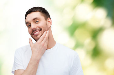 Image showing beautiful smiling man touching his face