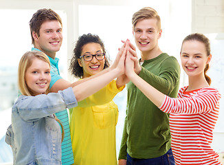 Image showing five smiling students giving high five at school