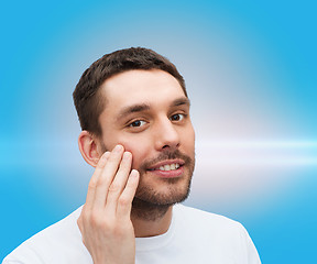 Image showing beautiful smiling man touching his face