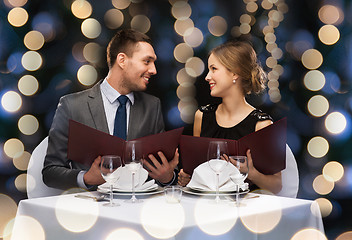 Image showing smiling couple with menus at restaurant