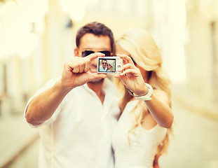 Image showing travelling couple taking photo picture with camera