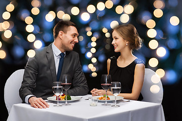 Image showing smiling couple eating main course at restaurant