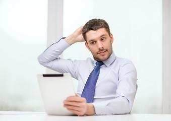 Image showing stressed businessman with tablet pc and documents