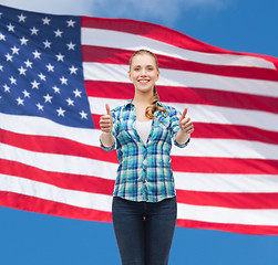 Image showing young woman in casual clothes showing thumbs up