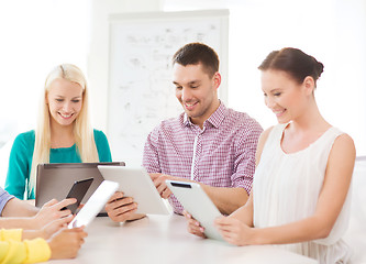 Image showing smiling team with table pc and laptop in office