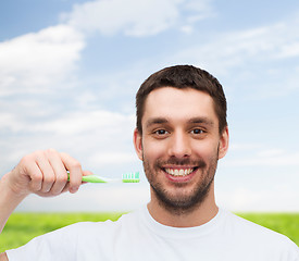 Image showing smiling young man with toothbrush