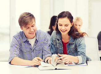 Image showing two teenagers with notebooks and book at school