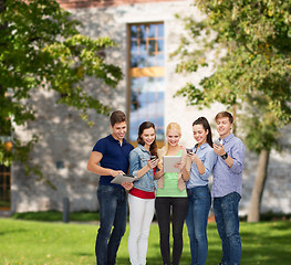 Image showing smiling students using smartphones and tablet pc