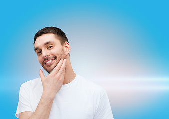 Image showing beautiful smiling man touching his face