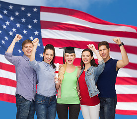 Image showing group of standing smiling students with diploma