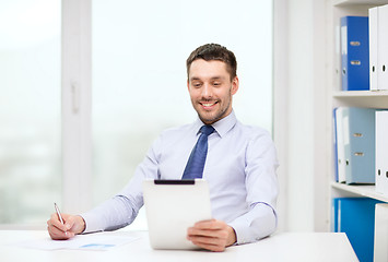 Image showing smiling businessman with tablet pc and documents