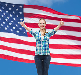 Image showing smiling girl in casual clothes showing thumbs up