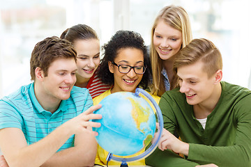 Image showing five smiling student looking at globe at school