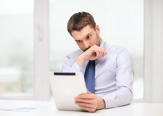 Image showing stressed businessman with tablet pc and documents