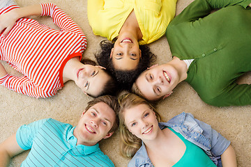 Image showing group of smiling people lying down on floor