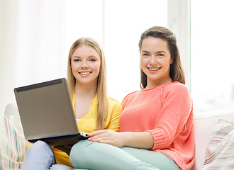 Image showing two smiling teenage girls with laptop at home