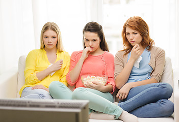 Image showing three sad teenage girl watching tv at home