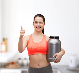 Image showing teenage girl with jar of protein showing thumbs up