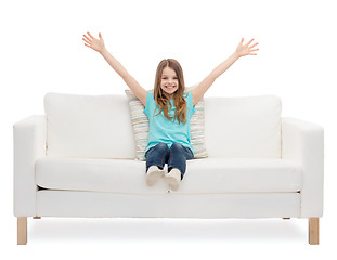 Image showing little girl sitting on sofa and waving hands