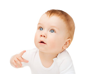 Image showing curious baby lying on floor and looking up