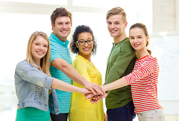 Image showing smiling students with hands on top of each other