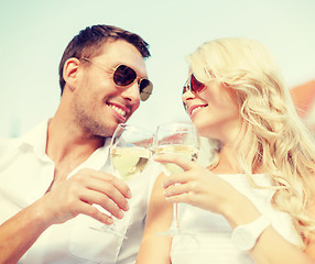 Image showing smiling couple in sunglasses drinking wine in cafe