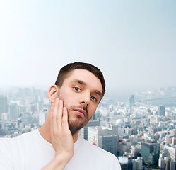 Image showing beautiful calm man touching his face