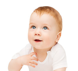 Image showing smiling baby lying on floor and looking up