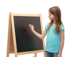 Image showing happy little girl with blackboard and chalk