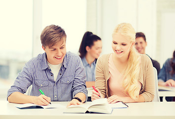 Image showing two teenagers with notebooks and book at school