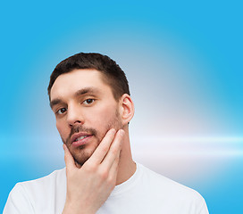 Image showing beautiful calm man touching his face