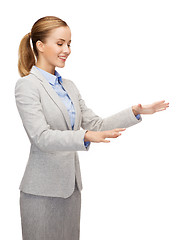 Image showing smiling businesswoman pointing to something