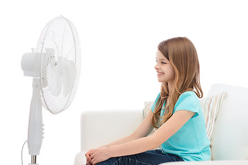 Image showing smiling little girl with big fan at home