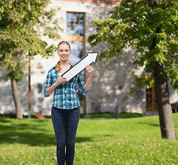 Image showing smiling young woman with arrow poiting up