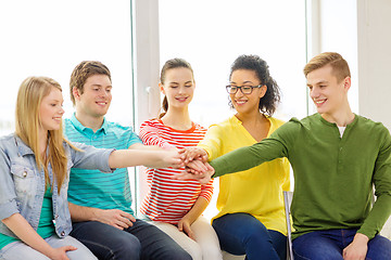 Image showing smiling students with hands on top of each other