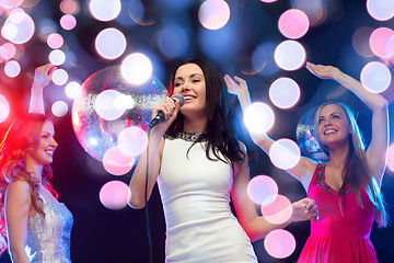 Image showing three smiling women dancing and singing karaoke