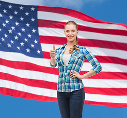 Image showing young woman in casual clothes showing thumbs up