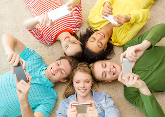 Image showing group of smiling people lying down on floor