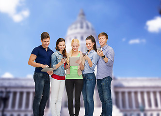 Image showing smiling students using smartphones and tablet pc