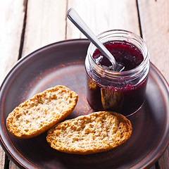 Image showing black currant jam in glass jar and crackers 