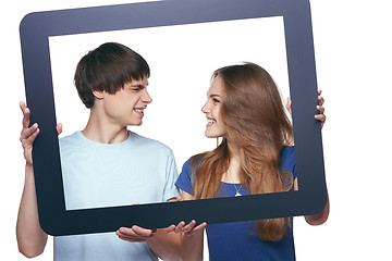 Image showing Happy couple holding tablet frame and looking at each other