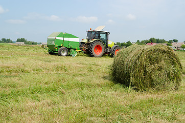 Image showing tractor bailer collect hay in agriculture field 