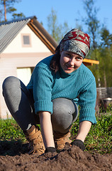 Image showing A young girl working in the garden at the cottage 