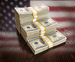 Image showing Thousands of Dollars with Reflection of American Flag on Table