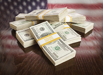 Image showing Thousands of Dollars with Reflection of American Flag on Table