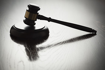 Image showing Dramatic Gavel Silhouette on Reflective Wood