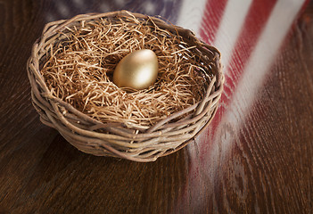 Image showing Golden Egg in Nest with American Flag Reflection on Table